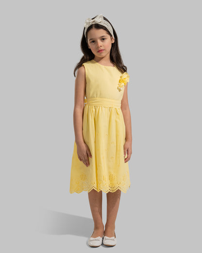 sleeveless pink cotton eyelet dress featuring a floral appliqué on the chest and a matching waist belt.